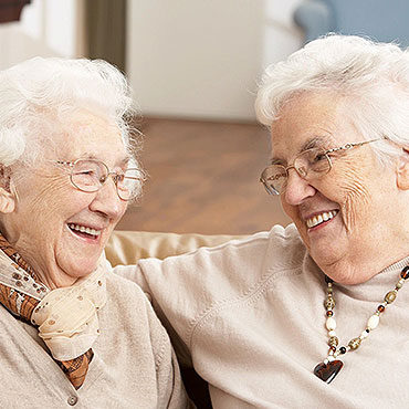 Two older women sitting next to each other.
